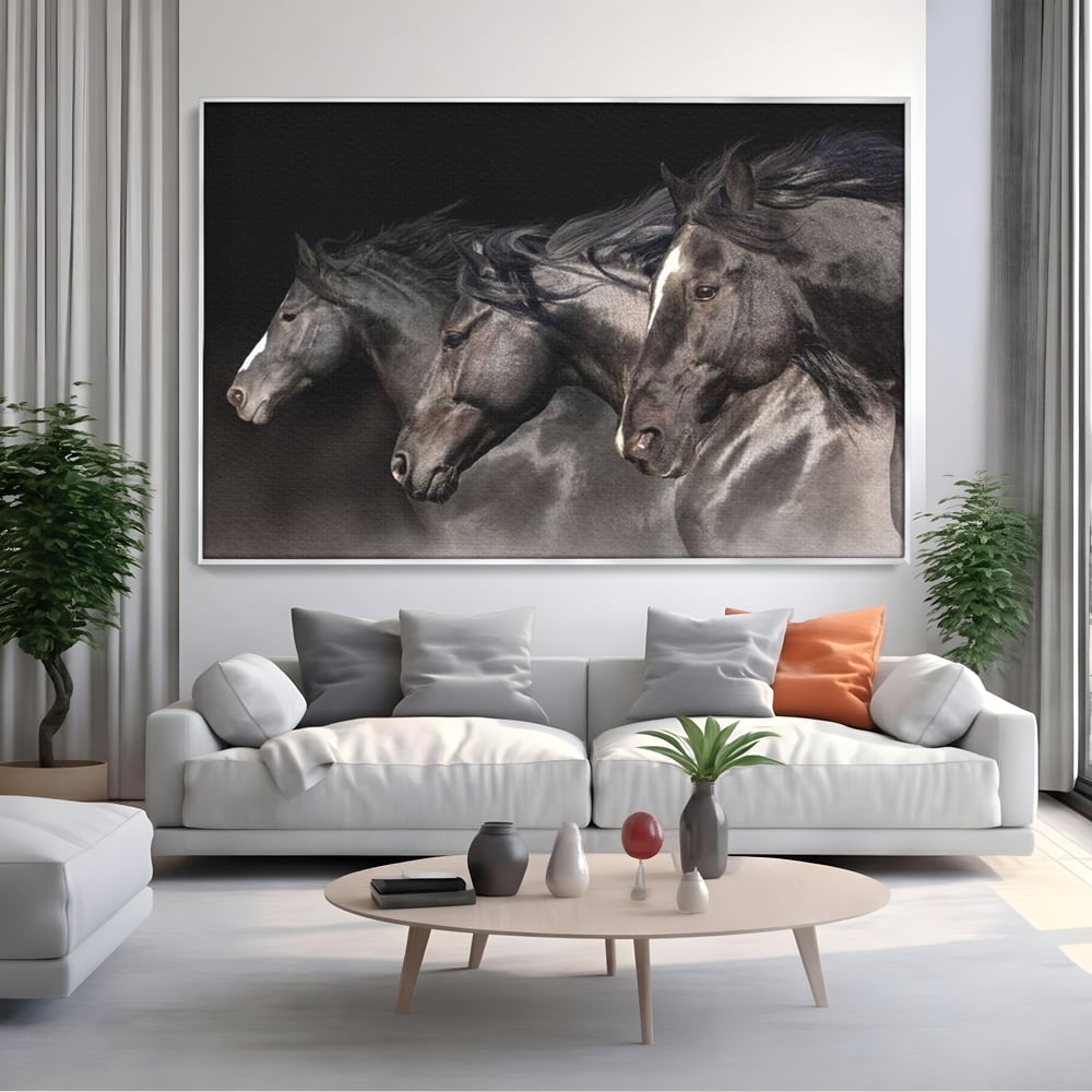 Tablou canvas cu tablou canvas cu trei cai negri in galop, in rama de aluminiu argintiu, pe perete intr-un living